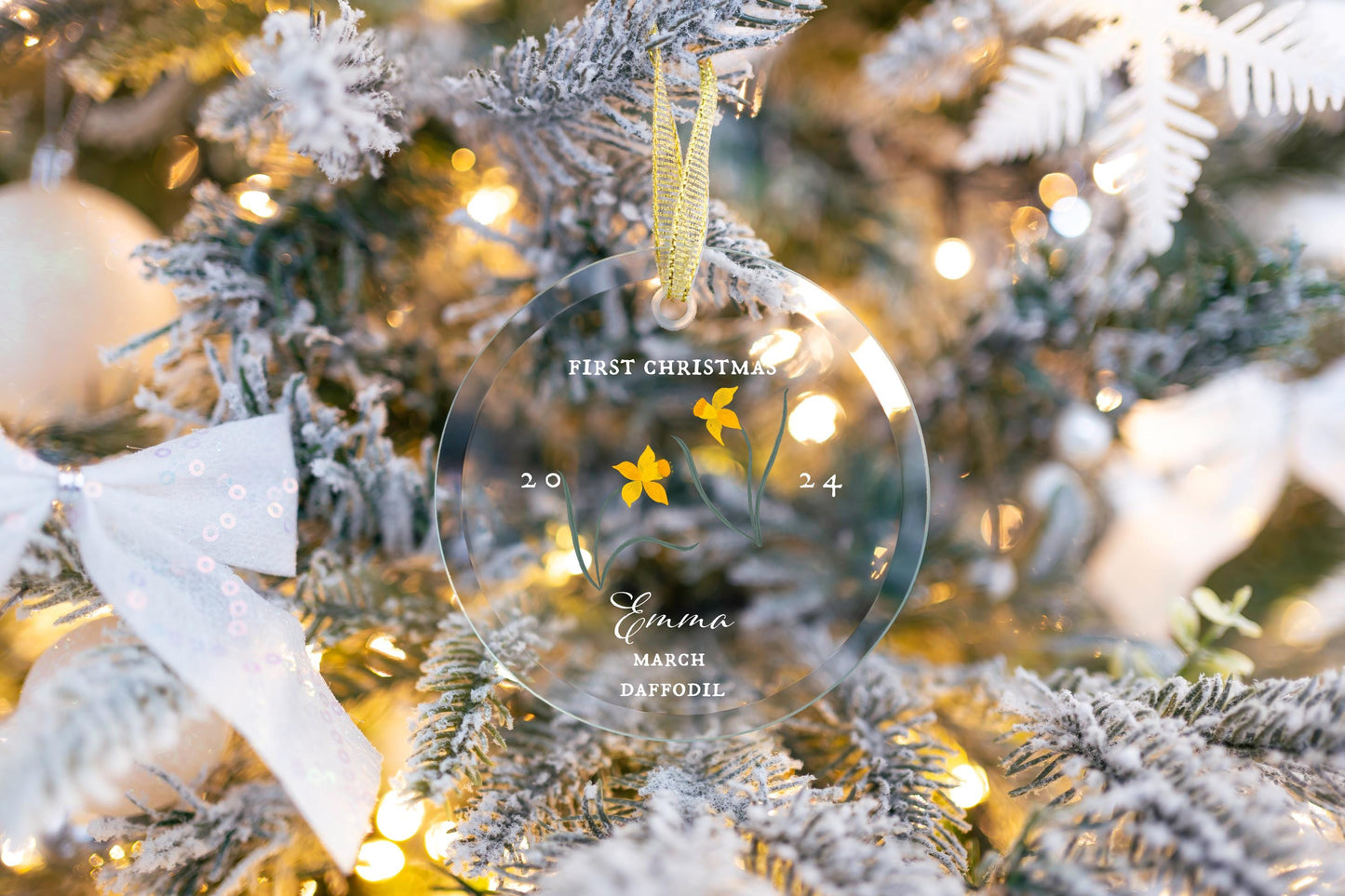 Personalized Babys First Christmas Ornament 2024, Custom March Birth Flower Glass Ornament gift hanging on a cute Christmas tree with gold ribbon decorated with pretty ribbons. Yellow Daffodil flowers botanical art by Danielle Silvie D&#39;Elia.